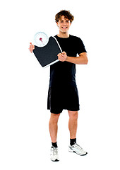Image showing Handsome fit man holding weight machine