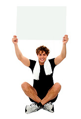 Image showing Handsome athlete holding blank placard