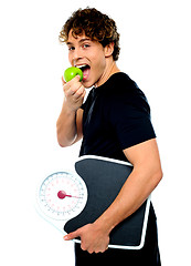 Image showing Smart boy eating green apple