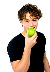 Image showing Young man eating fresh healthy green apple