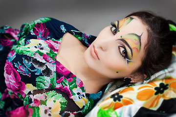 Image showing young happy girl lying with beautiful make up on her face