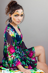 Image showing beautiful girl sitting on table with professional make up
