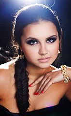 Image showing brunette girl posing in studio on dark background