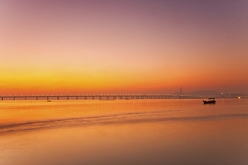 Image showing Sunset along the coast with bridge background