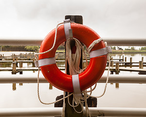 Image showing Red life belt in front of empty boat dock harbor