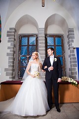 Image showing groom and bride during wedding ceremony in old town hall interior
