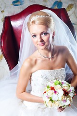 Image showing beautiful  bride sitting in red armchair