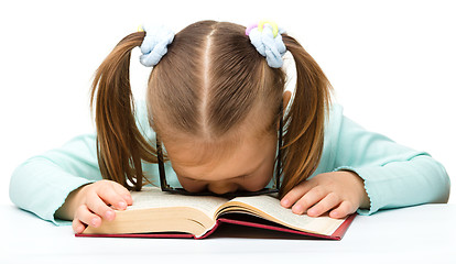 Image showing Little girl is sleeping on a book