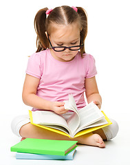 Image showing Cute little girl reads a book