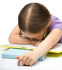 Image showing Cute little girl is sleeping on a book