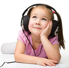 Image showing Cute little girl enjoying music using headphones