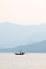 Image showing Fisherman over the ocean and between the mountain ridges