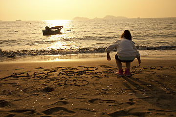 Image showing Asian children drawing on sand