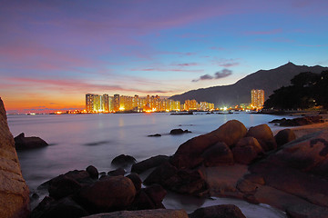 Image showing Sunset along seashore with long exposure of sea stones