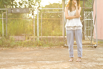 Image showing Asian woman standing and thinking in basketball court, half body