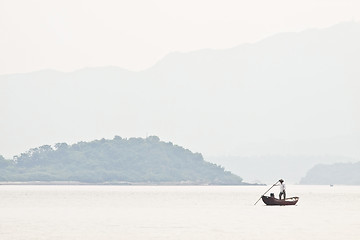 Image showing A fisherman on boat alone in the sea, low saturation picture.