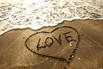 Image showing Love concept handwritten on sand