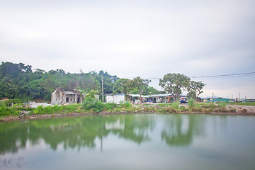 Image showing Chinese houses and garden with a pond outside