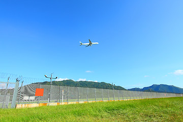 Image showing Airplane fly over grasses at day time