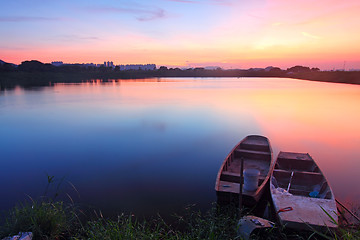 Image showing Sunset along the pond with isolated boats