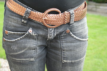 Image showing Blue jeans with brown belt