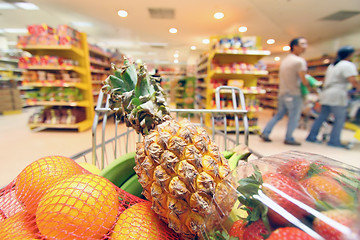 Image showing Moving shopping cart in supermarket. It was taken with a slow sh