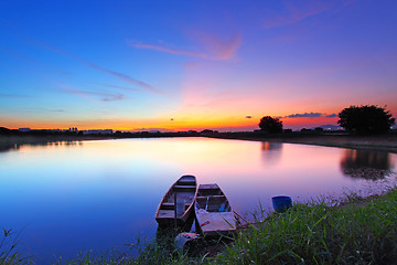 Image showing Sunset along the pond with two boats and two magical color on sk