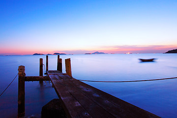 Image showing Sunset at dusk along a wooden pier