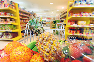 Image showing Moving shopping cart in supermarket. It was taken with a slow sh