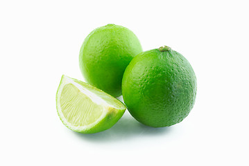Image showing Two green limes and slice
