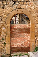 Image showing Old arched door blocked by brick wall