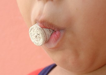 Image showing Kid with a cork in the mouth