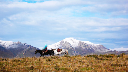 Image showing Snow-capped mountains with a rider on the horseback