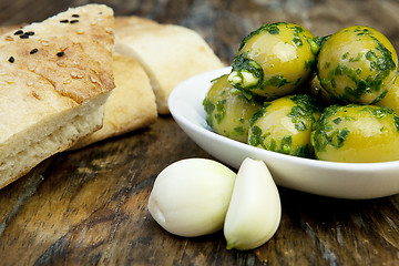 Image showing green olives with fresh bread and herbs