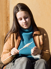 Image showing Girl spins a yarn of wool