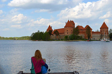 Image showing Mother hug son sit on bridge front Trakai Castle 