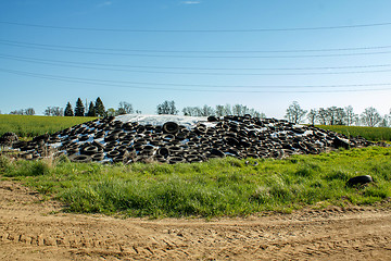 Image showing silage by farmers using old tires as a burden