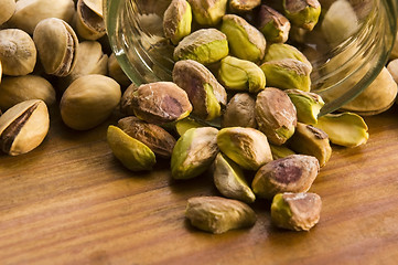 Image showing Roasted pistachios on natural wooden table