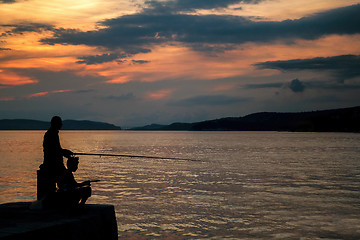 Image showing Silhouettes of Fishermen on the pier at sunset 