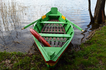Image showing Rowing wooden boat on lake shore and resque circle 
