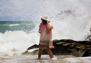 Image showing The lady in the white hat is the wave on the beach