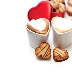 Image showing heart shaped cream cookies on red heart metal box and coffee