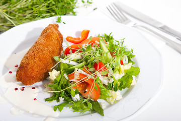 Image showing garlic chicken kiev with mixed leaf salad