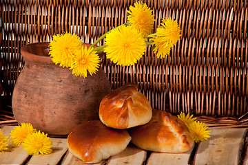 Image showing three pies and dandelions in  clay pot