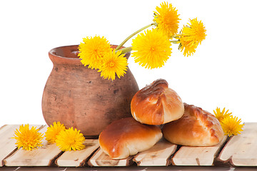 Image showing three pies and dandelions in  clay pot