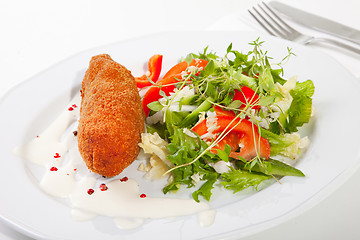 Image showing garlic chicken kiev with mixed leaf salad