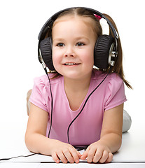 Image showing Cute little girl enjoying music using headphones