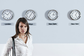 Image showing Businesswoman In Front Of World Time Zone Clocks