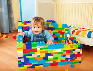 Image showing toddler sitting a castle of toy blocks