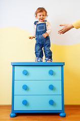 Image showing Kid jumping from the cabinet